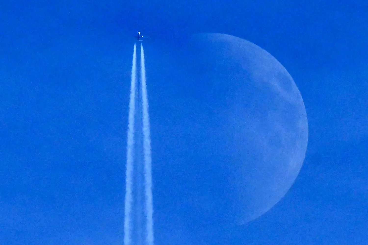 A Boeing 737 Max 8-200 aircraft of Irish budget airline Ryanair flies past the Waxing crescent moon in Frankfurt am Main, western Germany on December 27, 2025. (AFP)