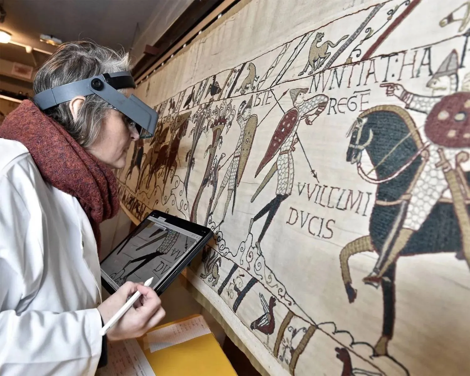 This photo provided by Bayeux townhall shows a technician inspecting the famed Bayeux tapestry in Bayeux, Normandy, in 8th January, 2020. (Ville de Bayeux via AP/File photo)