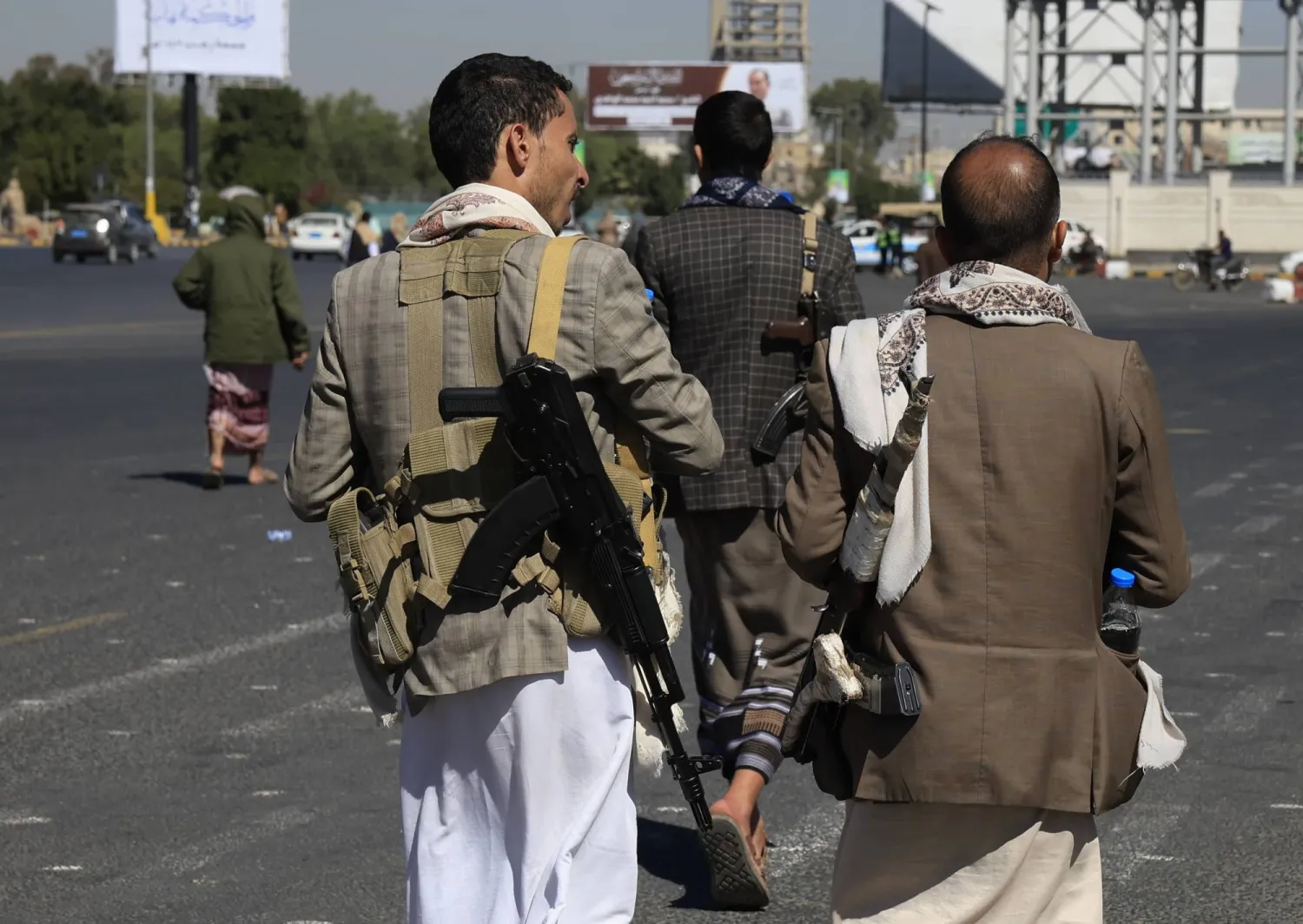 مسلحون حوثيون يسيرون في أحد شوارع العاصمة اليمنية المختطفة صنعاء (إ.ب.أ)