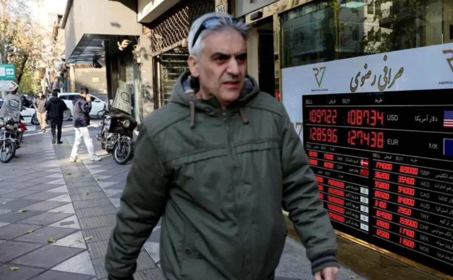 A man walks past a sign at a currency exchange bureau as the value of the Iranian rial drops, in Tehran, Iran, December 20, 2025. (Via Reuters)
