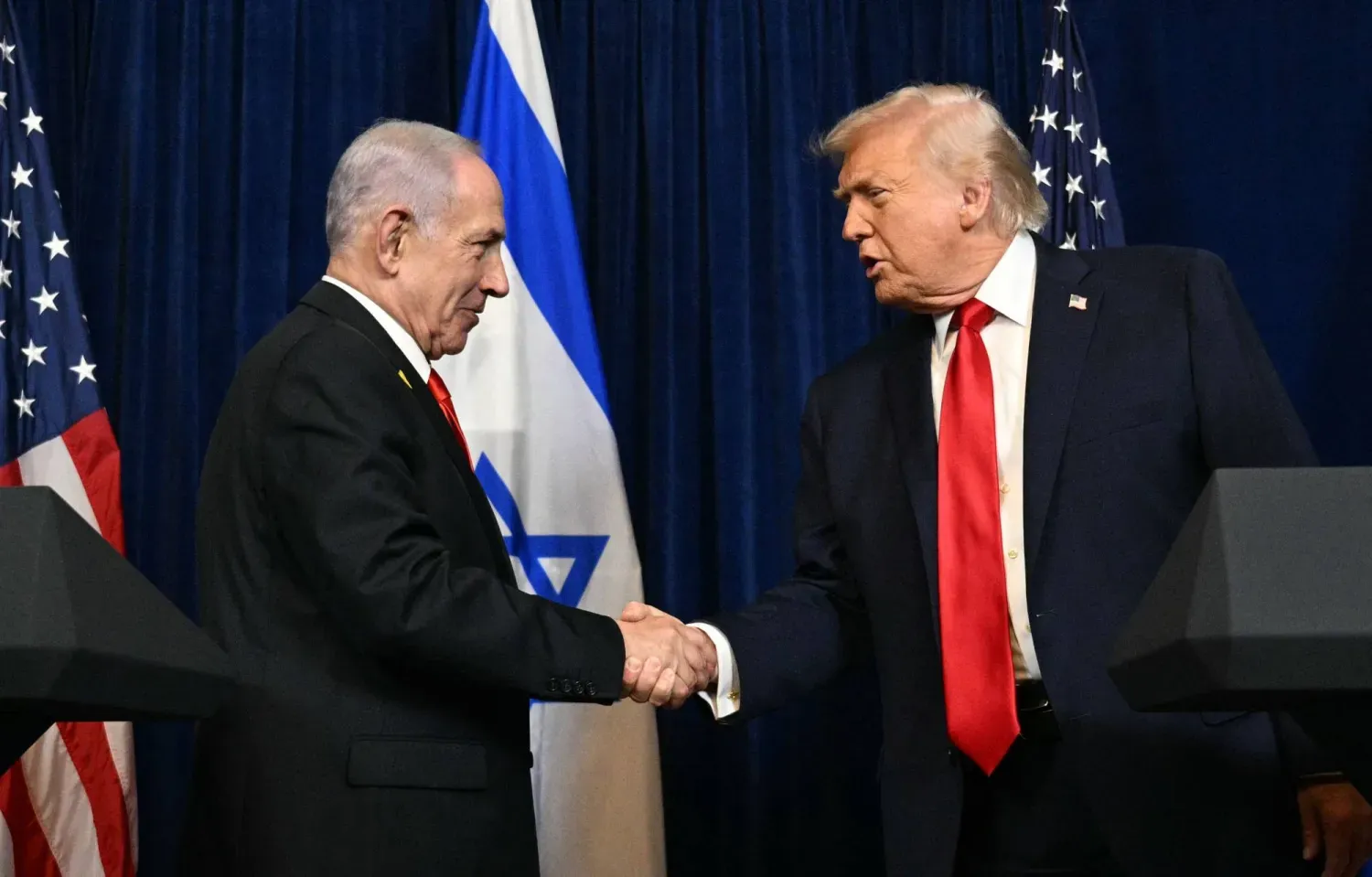 Trump, Florida'daki görüşmelerinin ardından Netanyahu ile tokalaşıyor (AFP)