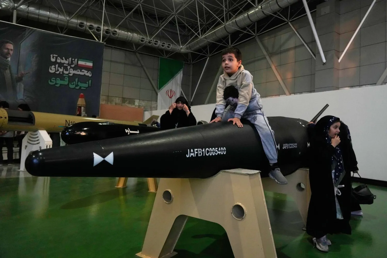 طفل يجلس فوق رأس حربي لصاروخ باليستي في المعرض الدائم التابع لـ«الحرس الثوري» بضواحي طهران نوفمبر الماضي (أ.ب)