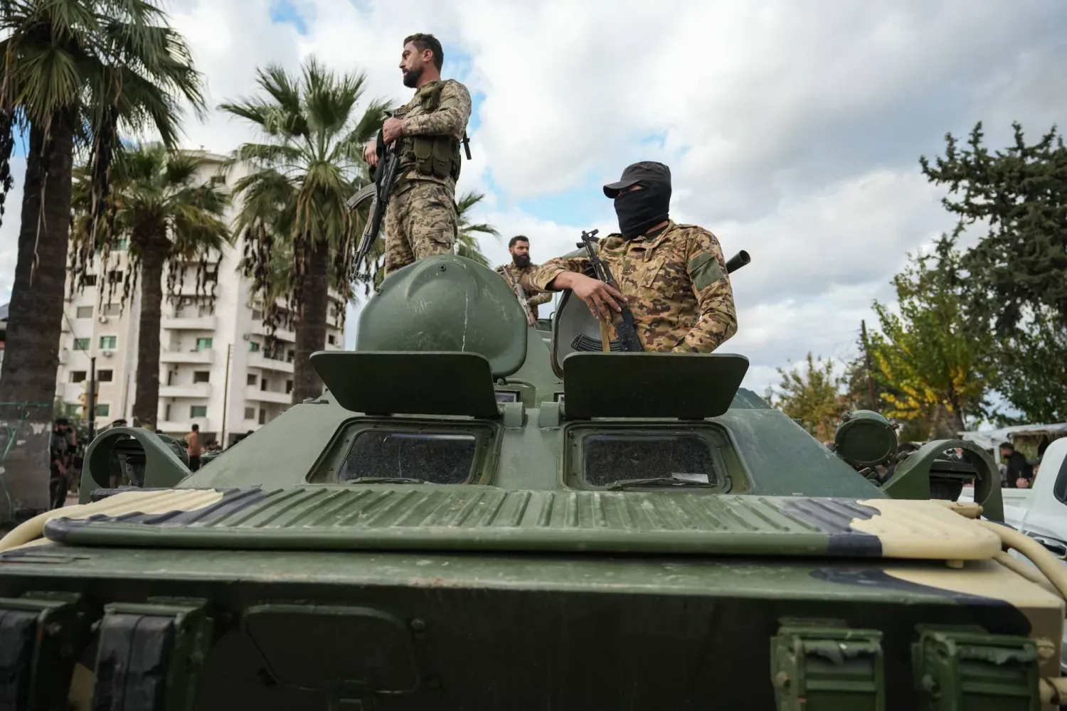 Suriye güvenlik güçleri Lazkiye kentindeki çatışmaların ardından bir askeri aracın üzerinde (EPA)