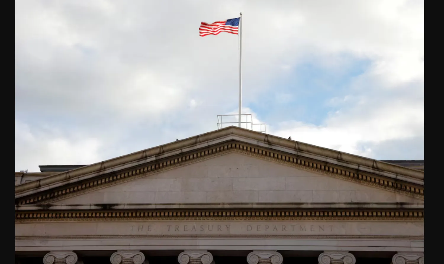 العلم الأميركي يرفرف فوق مبنى وزارة الخزانة في واشنطن (رويترز)