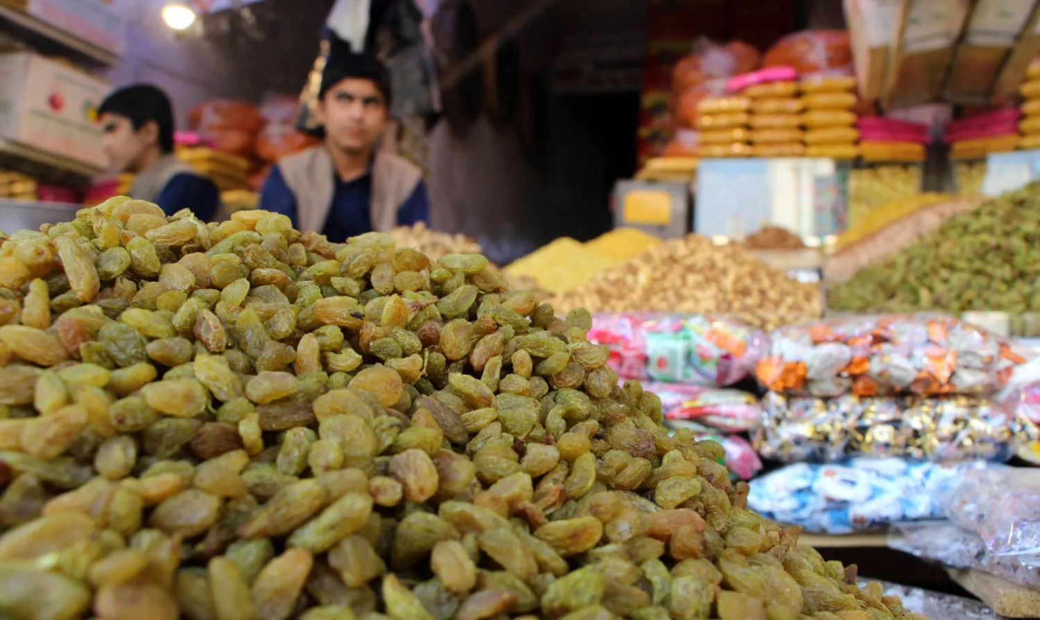 بائع أمام محل للمكسرات في قندهار... وتعد المكسرات أحد أهم المصادر الغذائية الغنية بالزنك (إ.ب.أ)