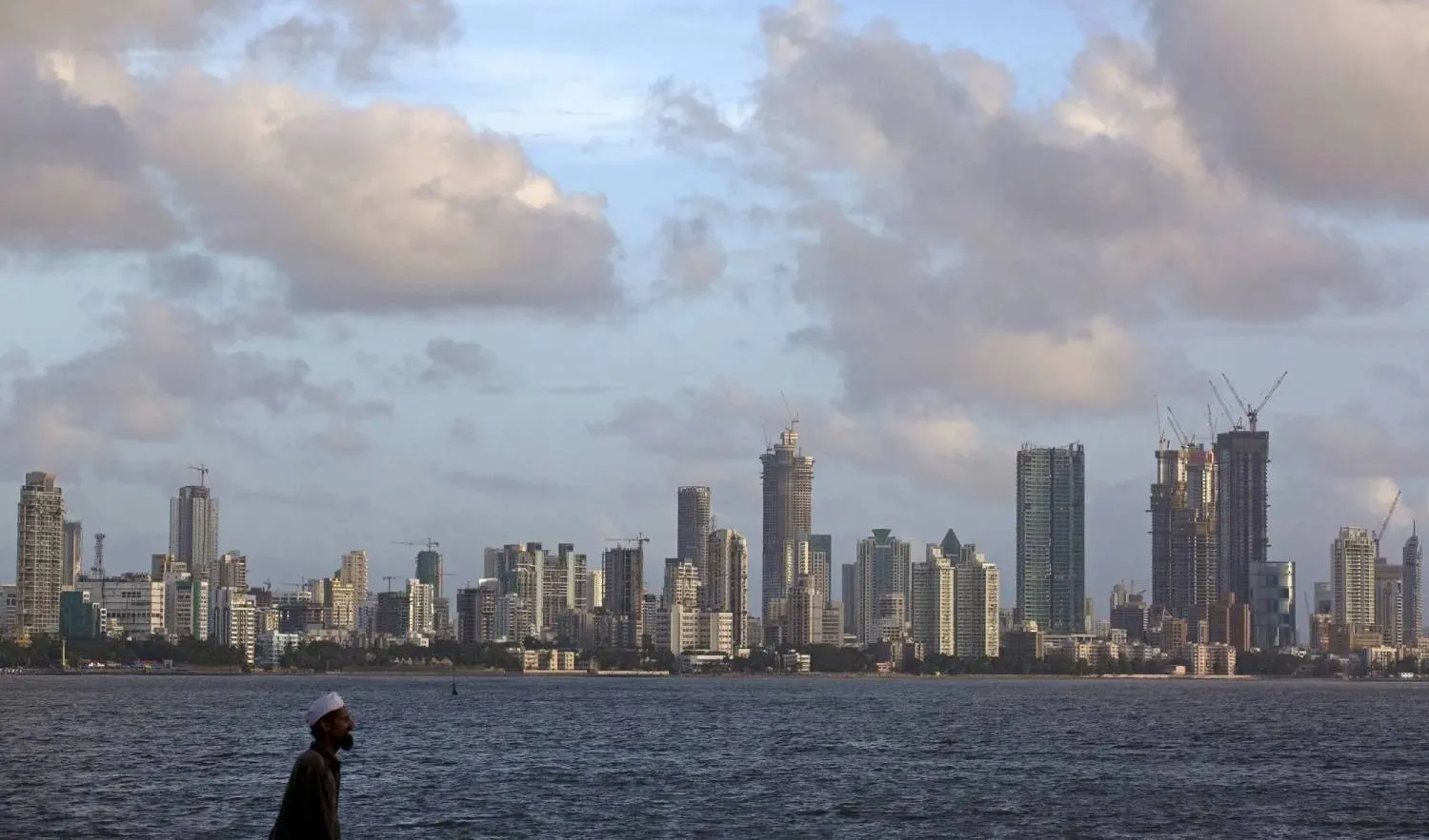  A man walks at the seafront as scattered clouds are seen over Mumbai's skyline, India, June 10, 2015. (Reuters)