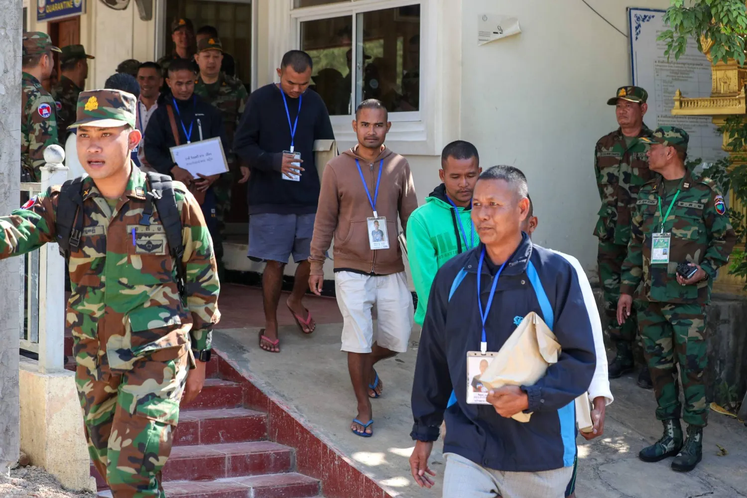 This handout photo taken and released by Agence Kampuchea Press (AKP) on December 31, 2025 shows Cambodian soldiers, who had been captured by Thai soldiers in July, being escorting by Cambodian soldiers after their release, as they walk at a checkpoint along the border with Thailand in Cambodia's Pailin province. (Ja Dina / Agence Kampuchea Press (AKP) / AFP) 