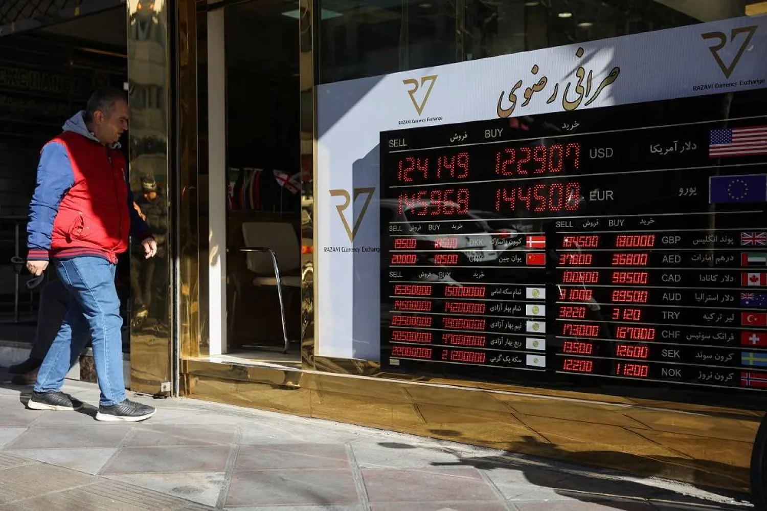 A person walks past a sign at a currency exchange, as the value of the Iranian rial drops, in Tehran, Iran, December 30, 2025. Majid Asgaripour/WANA (West Asia News Agency) via Reuters