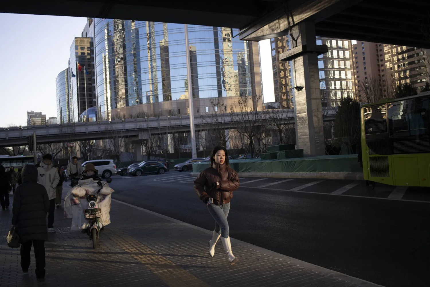 امرأة تجري في أحد شوارع وسط العاصمة الصينية بكين (إ.ب.أ)