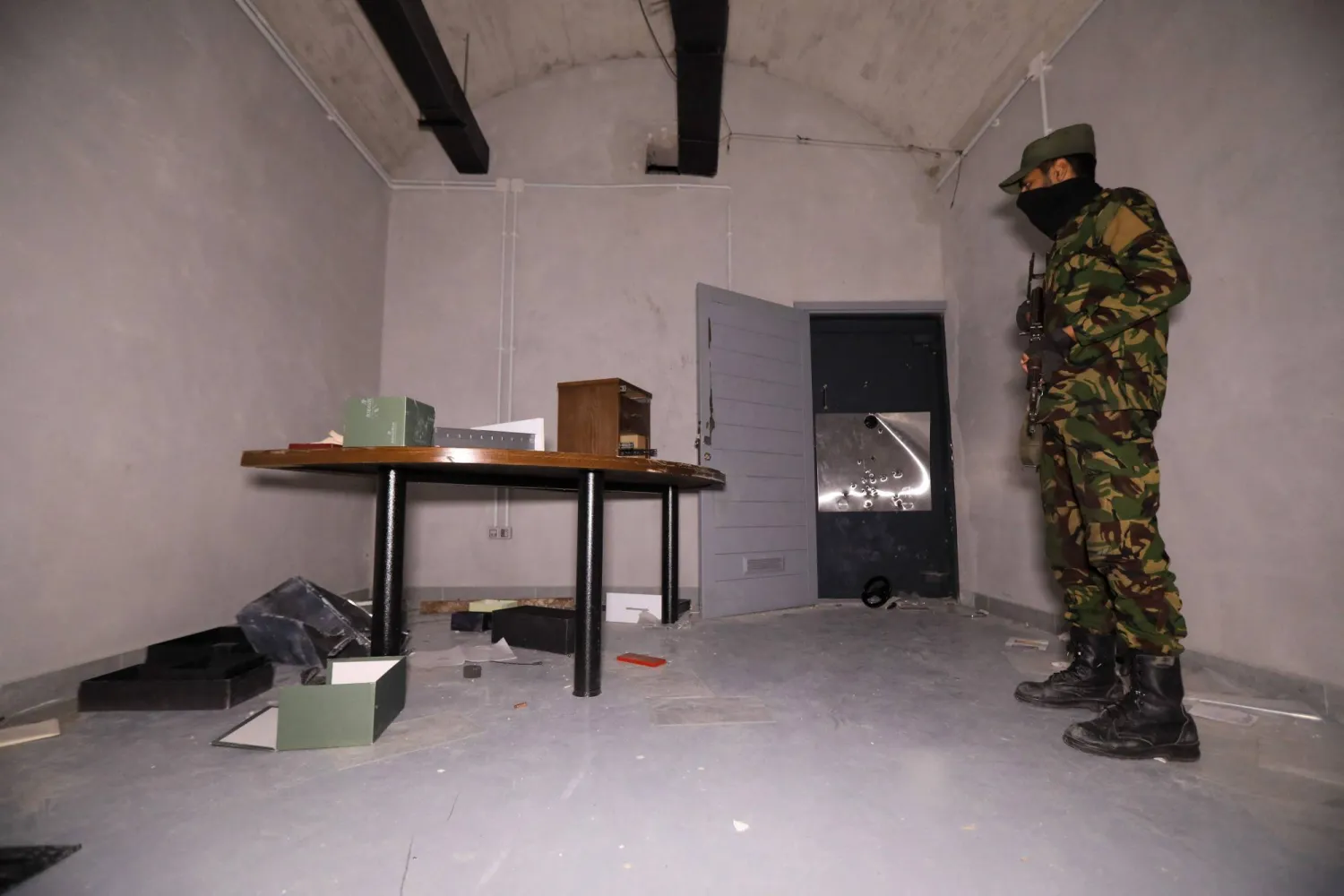 عنصر من قوات الأمن التابعة للسلطات السورية الجديدة في غرفة تحت الأرض بمكاتب ماهر الأسد على مشارف دمشق (أ.ف.ب)