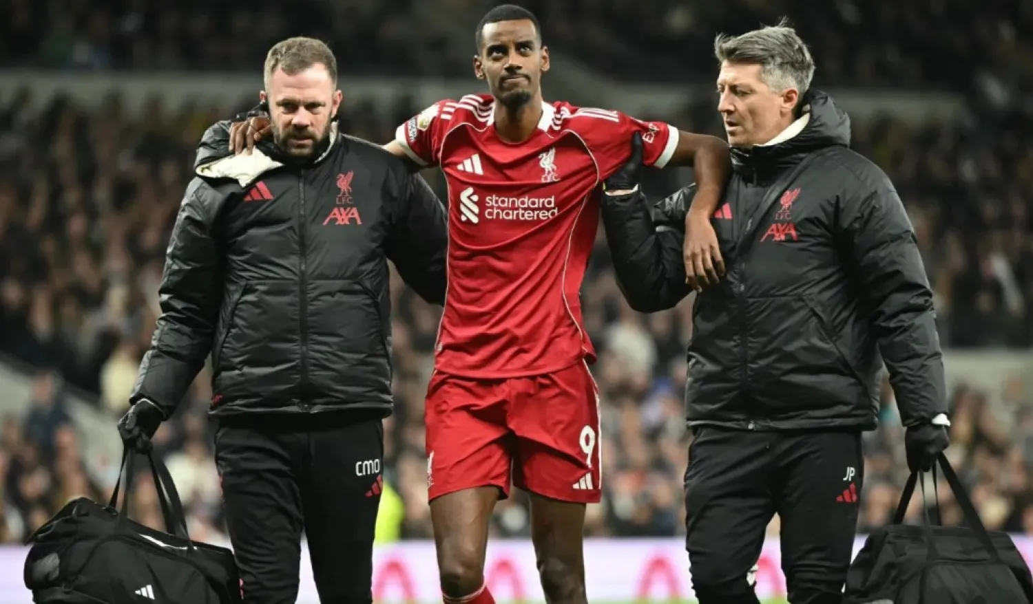 Liverpool's Swedish striker #09 Alexander Isak (C) is helped off the field by medical staff after picking up an injury during the English Premier League football match between Tottenham Hotspur and Liverpool at the Tottenham Hotspur Stadium in London, on December 20, 2025. (Photo by JUSTIN TALLIS / AFP)
