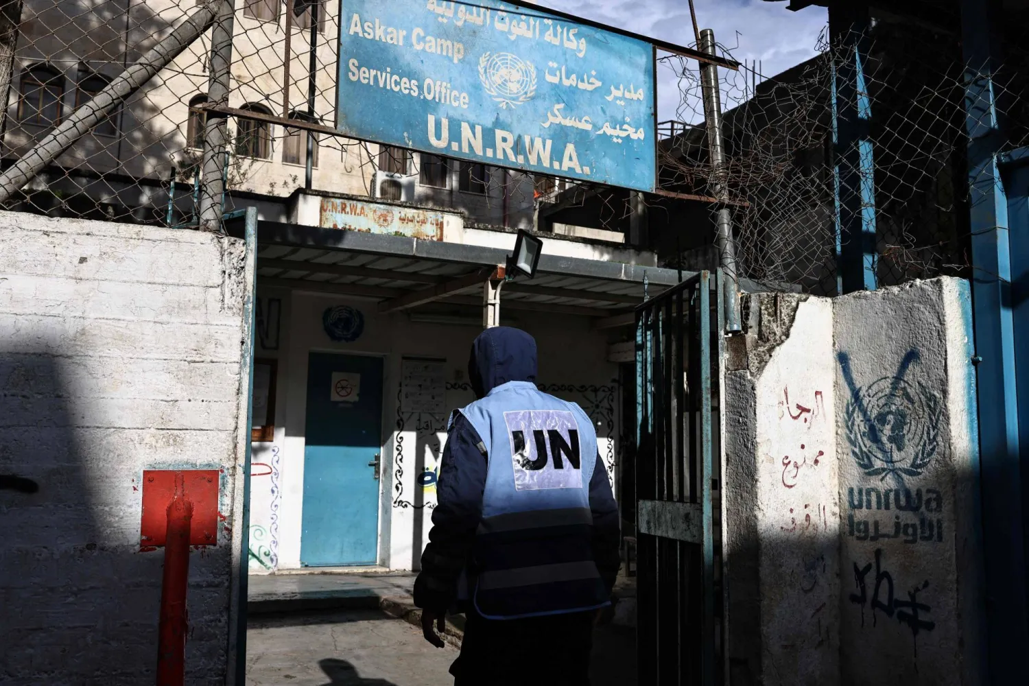 شخص يدخل منشأة تتبع وكالة «الأونروا» في مخيم عسكر بنابلس بالضفة الغربية (أ.ف.ب)