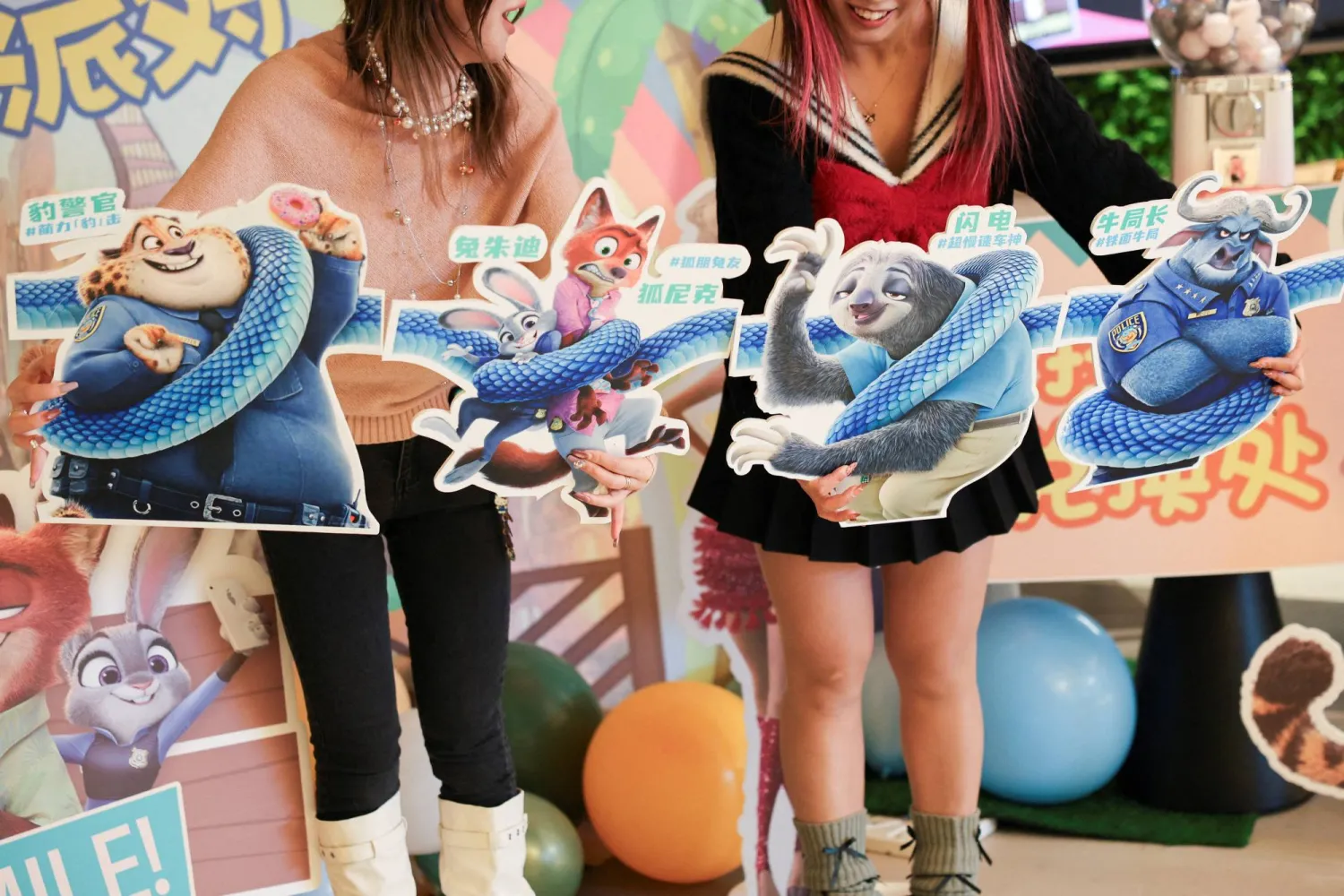 FILE PHOTO: Moviegoers hold character cutouts to pose for a photo at a movie theater on the release day of the movie Zootopia 2, in Shanghai, China, November 26, 2025. REUTERS/Go Nakamura/File Photo