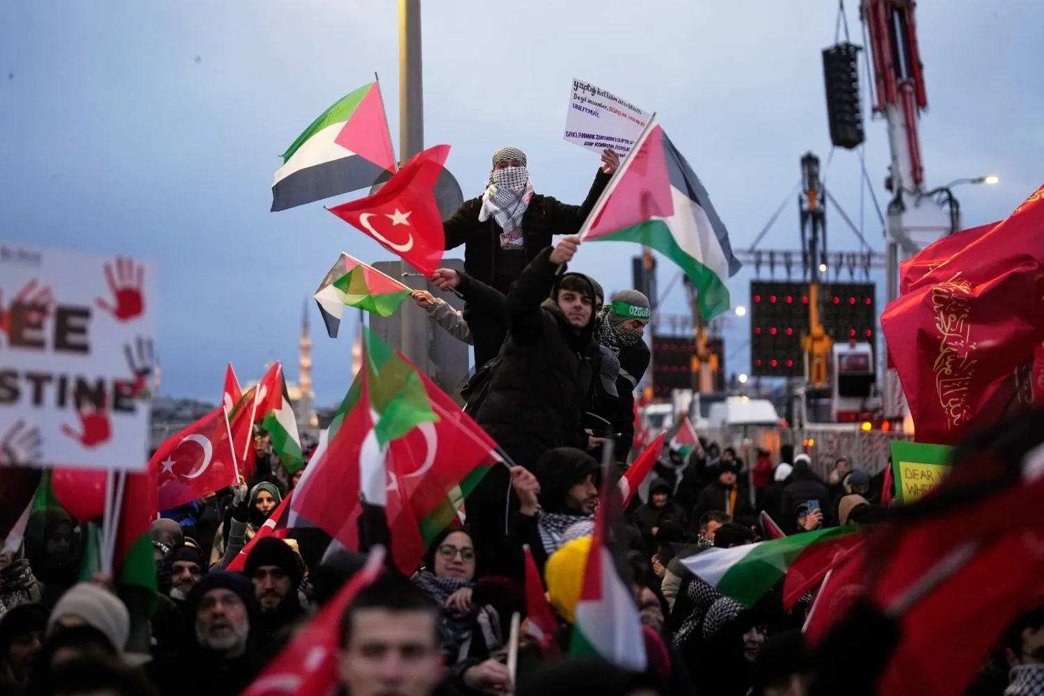 Demonstrators gather on the Galata Bridge holding Palestinian and Turkish flags during a pro-Palestinian rally in Istanbul, Türkiye, Thursday, Jan. 1, 2026. (AP Photo/Khalil Hamra)