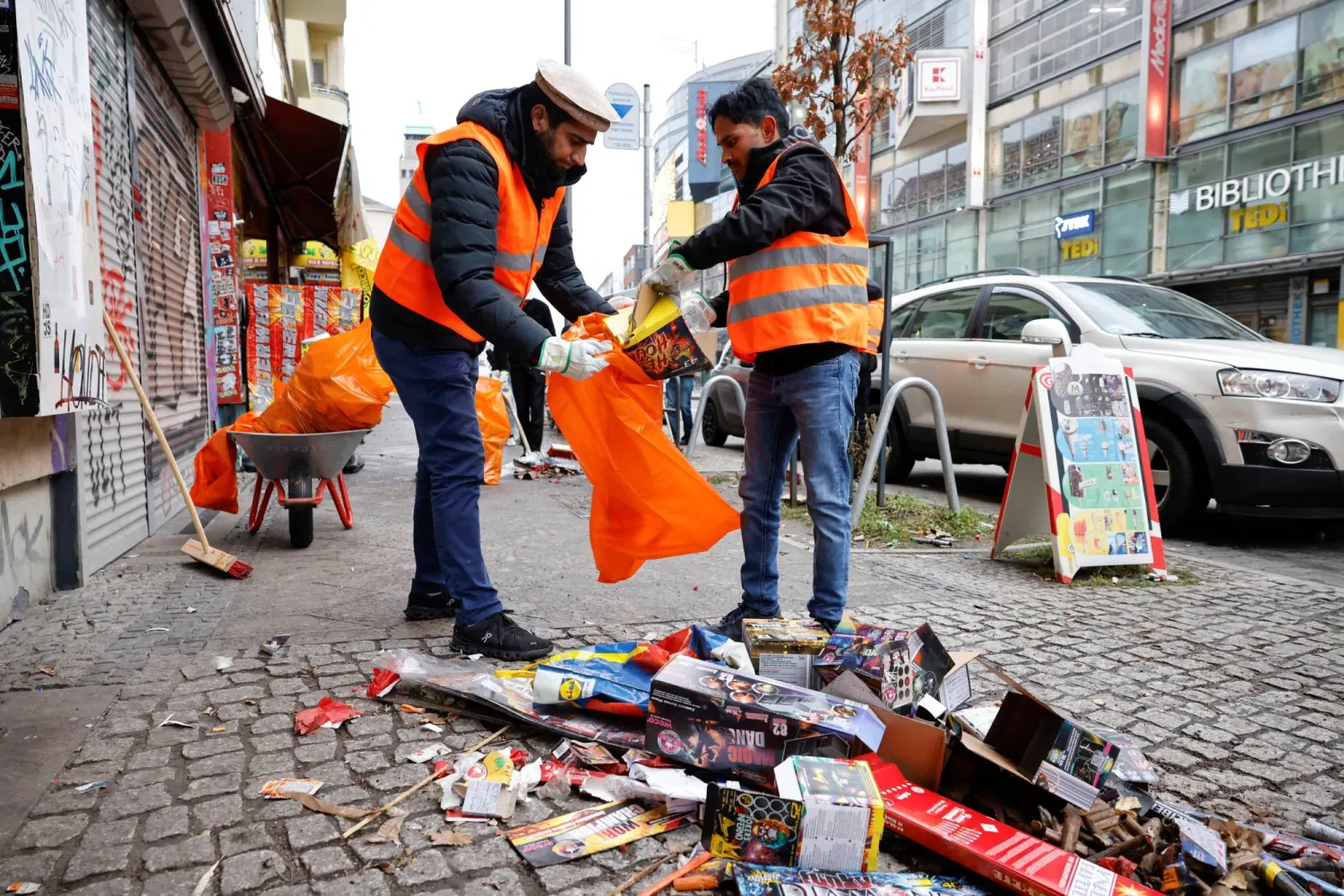 شباب مسلمون يشاركون في تنظيف الشوارع من مخلفات ليلة رأس السنة (رويترز)