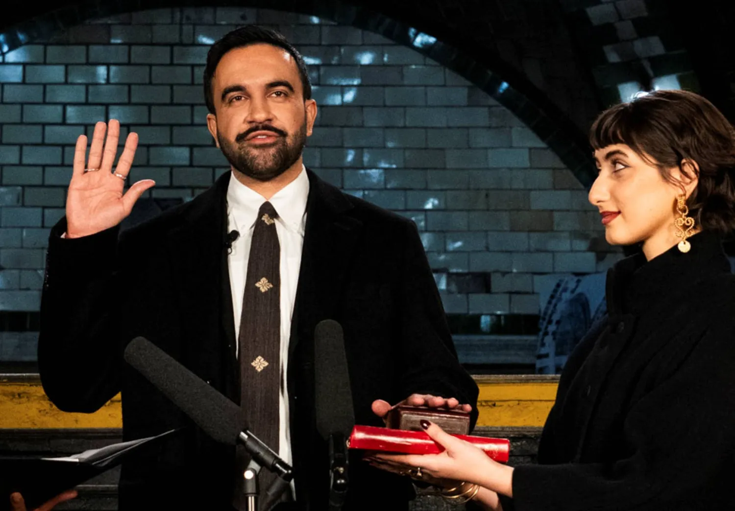 ممداني لدى أدائه القسم على نسخة من المصحف حملتها زوجته في نيويورك أمس (رويترز)