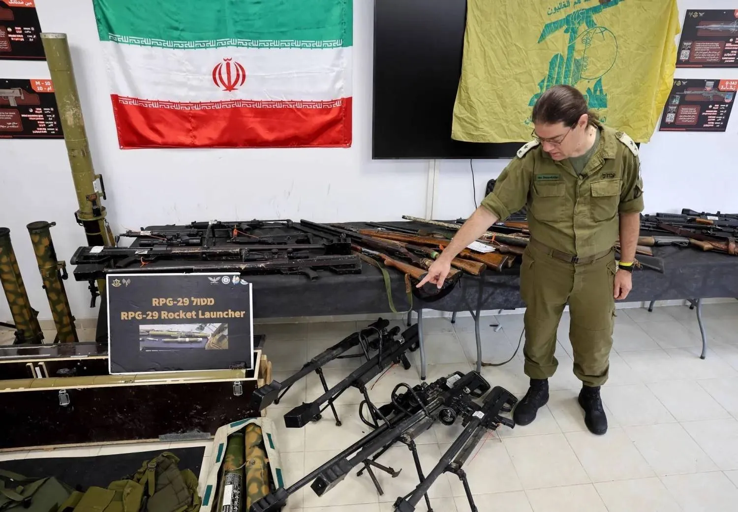 An Israeli officer displays weapons seized by the army in Gaza, Lebanon and Syria during a media tour (AFP). 