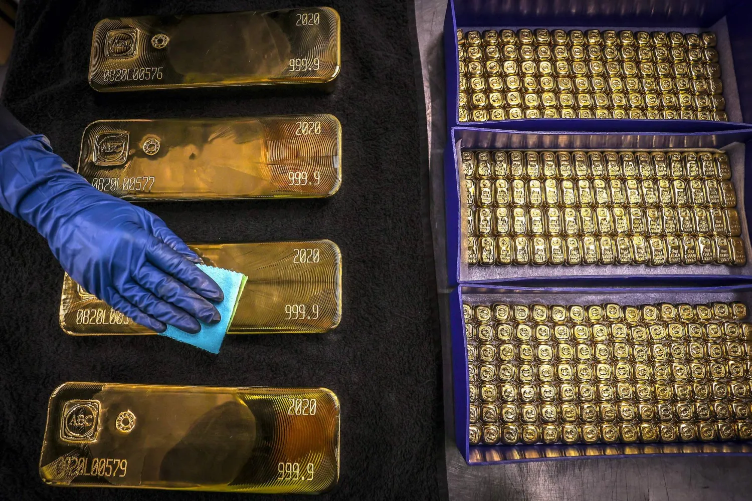 (FILES) A worker polishes gold bullion bars at the ABC Refinery in Sydney on August 5, 2020. (Photo by DAVID GRAY / AFP)