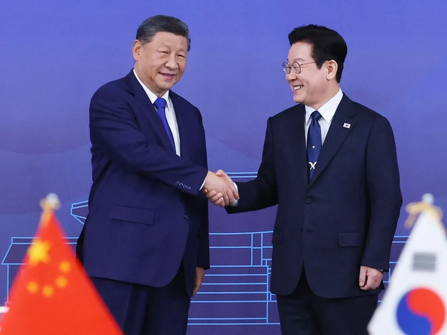 الرئيس الصيني شي جينبينغ ورئيس كوريا الجنوبية لي ​جيه-ميونغ في صورة من لقاء نوفمبر الماضي (أ.ف.ب) 