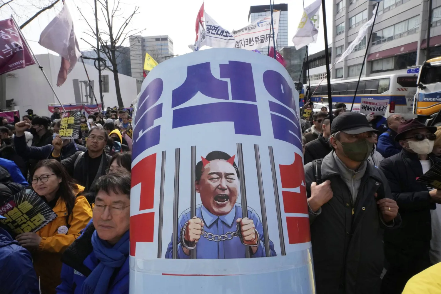 Protesters attend a rally calling for impeached South Korean President Yoon Suk Yeol to step down near the Constitutional Court in Seoul, South Korea, Monday, March 17, 2025. The letters read "Arrest Yoon Suk Yeol " (AP Photo/Ahn Young-joon)