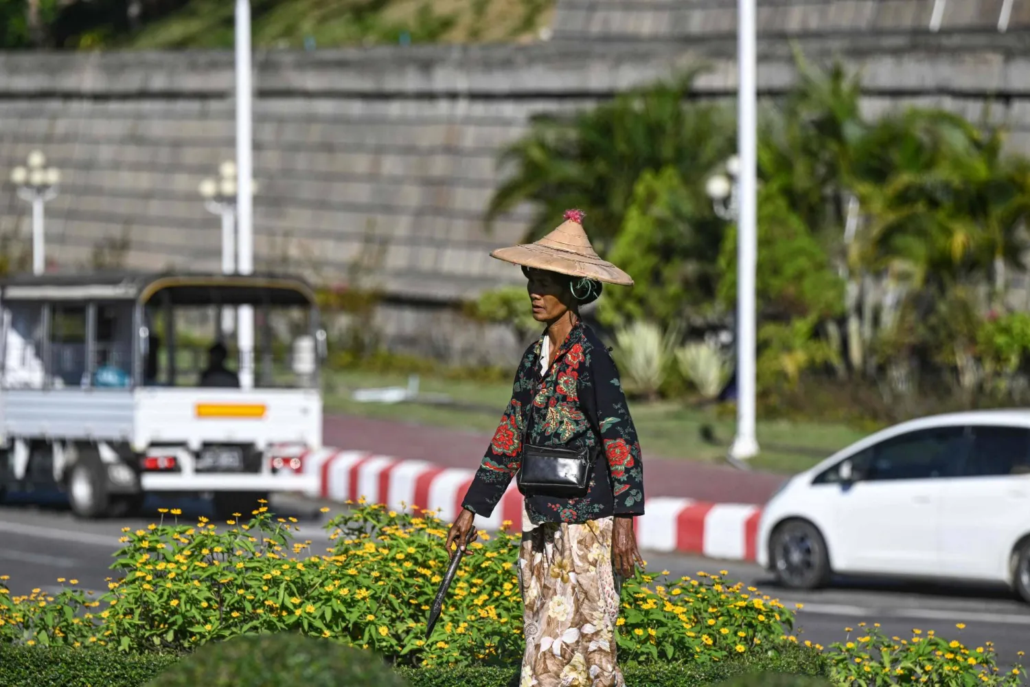 امرأة تسير على جانب الطريق في نايبيداو بعد يوم من المرحلة الأولى من الانتخابات العامة في ميانمار (أ.ف.ب)