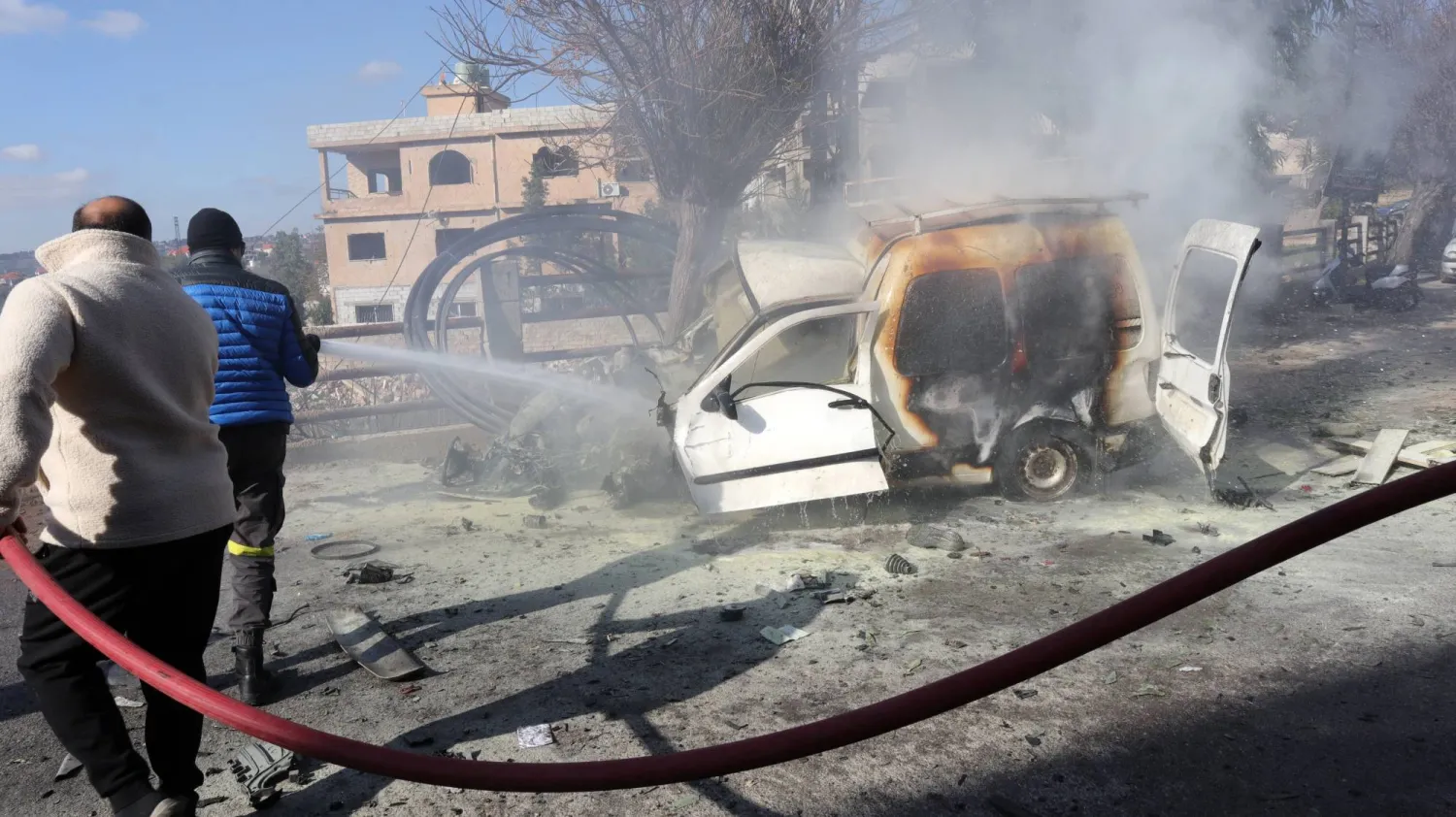 عناصر من الدفاع المدني يعملون على إخماد نيران اندلعت في سيارة استهدفتها غارة إسرائيلية في بلدة الخيام بجنوب لبنان (إ.ب.أ)