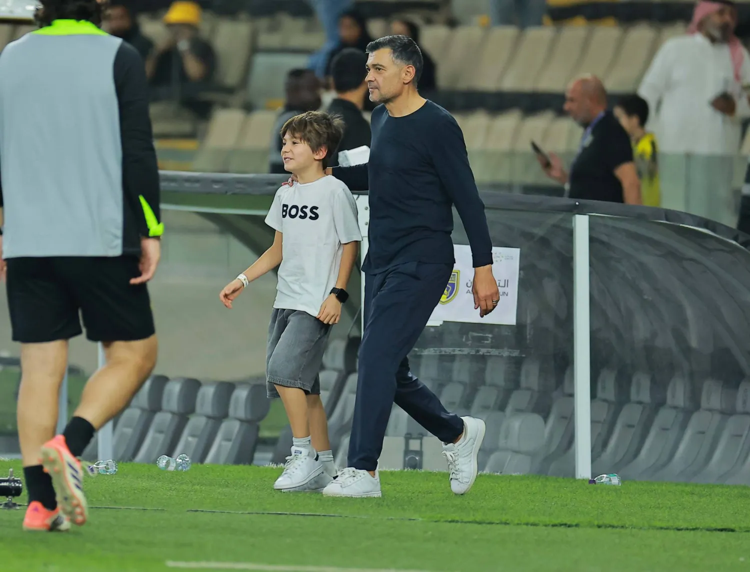 كونسيساو مدرب الاتحاد رفقة طفله بعد المباراة (تصوير: محمد المانع)