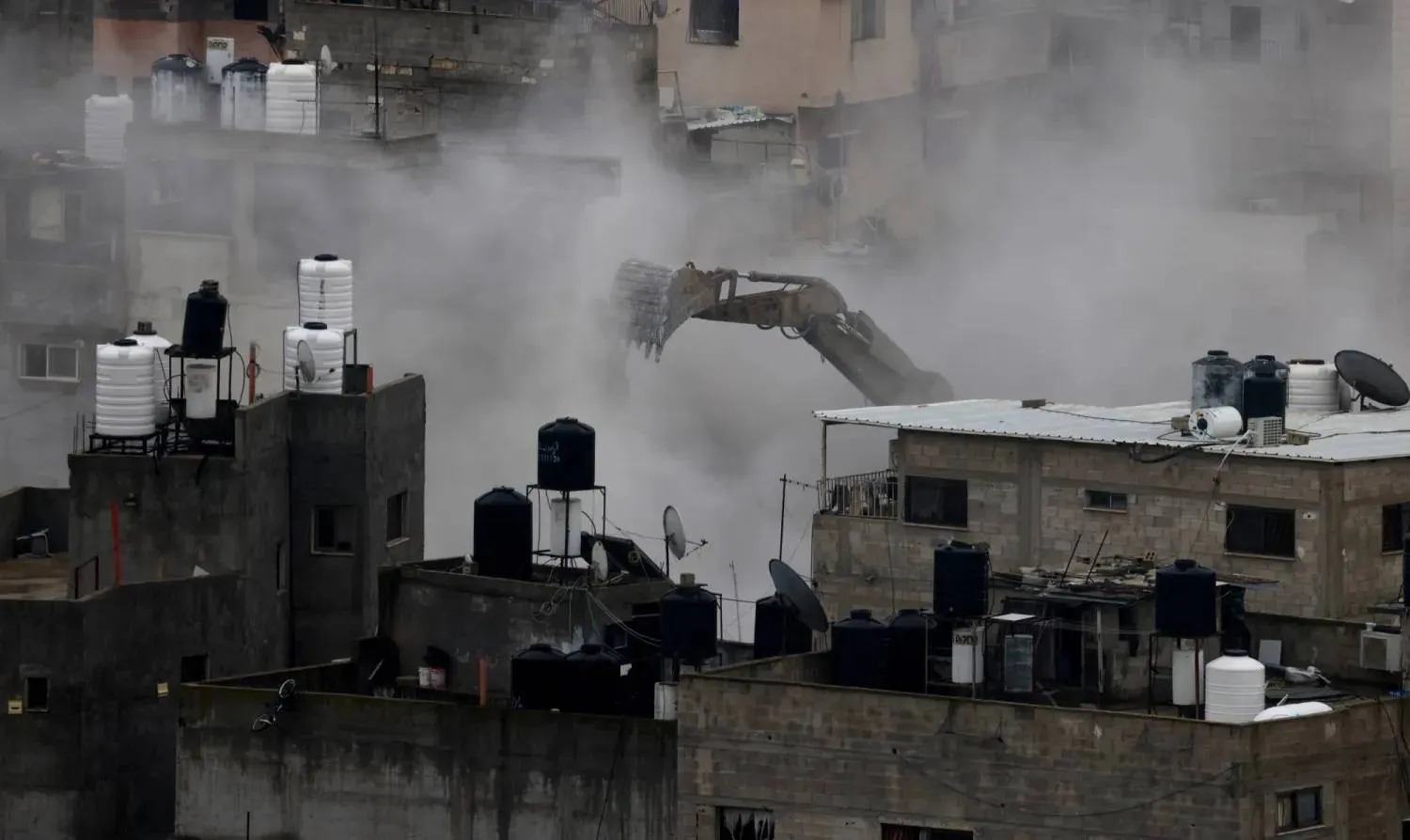 An Israeli army excavator demolishes buildings during a military operation in Nur Shams refugee camp, near the West Bank city of Tulkarem, 31 December 2025. (EPA) 