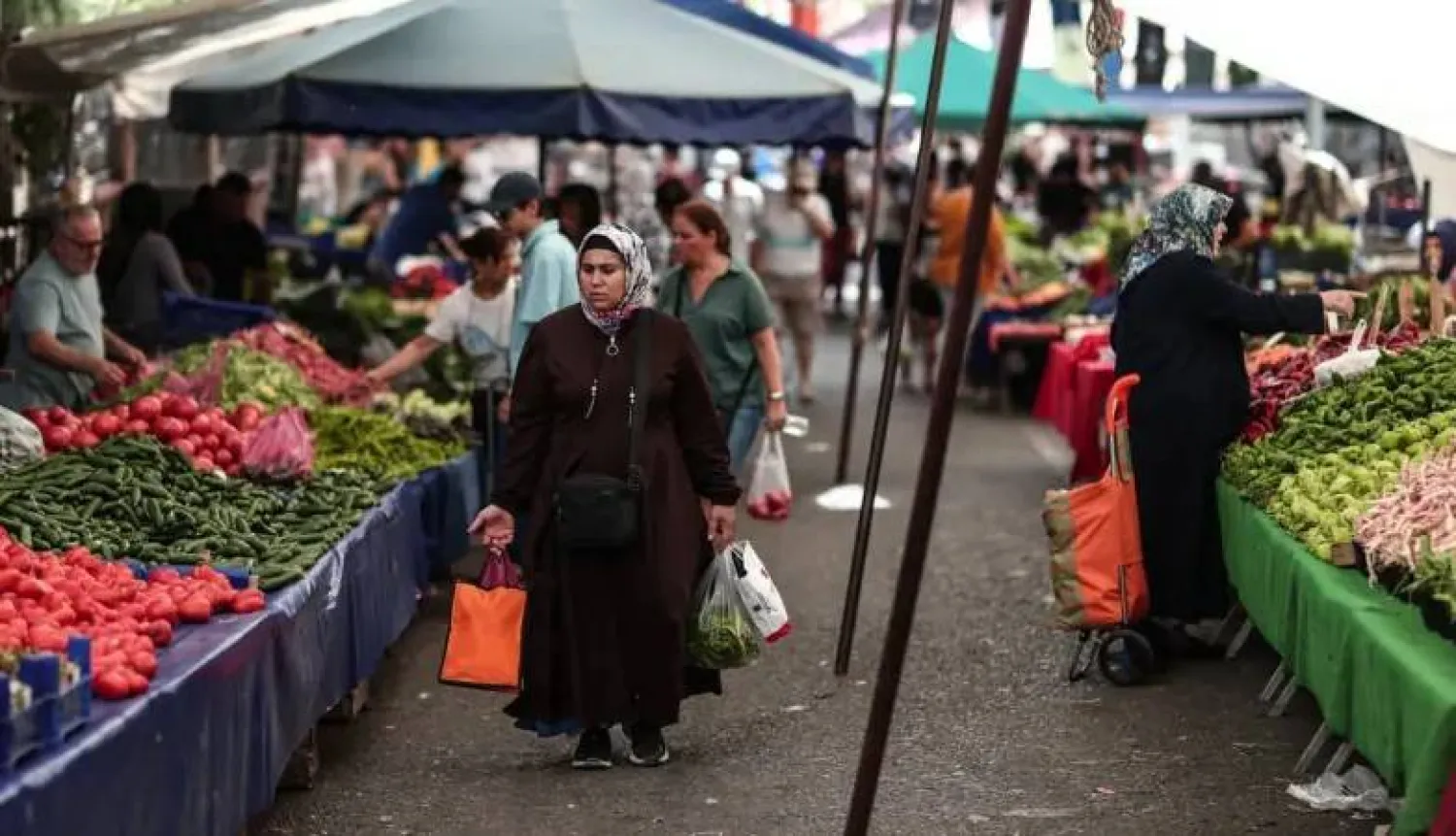 متسوقون داخل سوق للخضراوات والفاكهة في إسطنبول (إ.ب.أ)