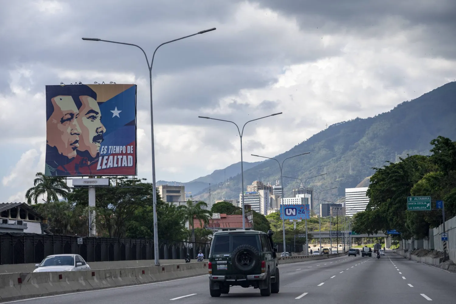 ملصق يحمل صورة الرئيسين الراحل هوغو تشافيز والحالي نيكولاس مادورو الذي اعتقلته الولايات المتحدة مع عبارة «حان وقت الحرية» (د.ب.أ)