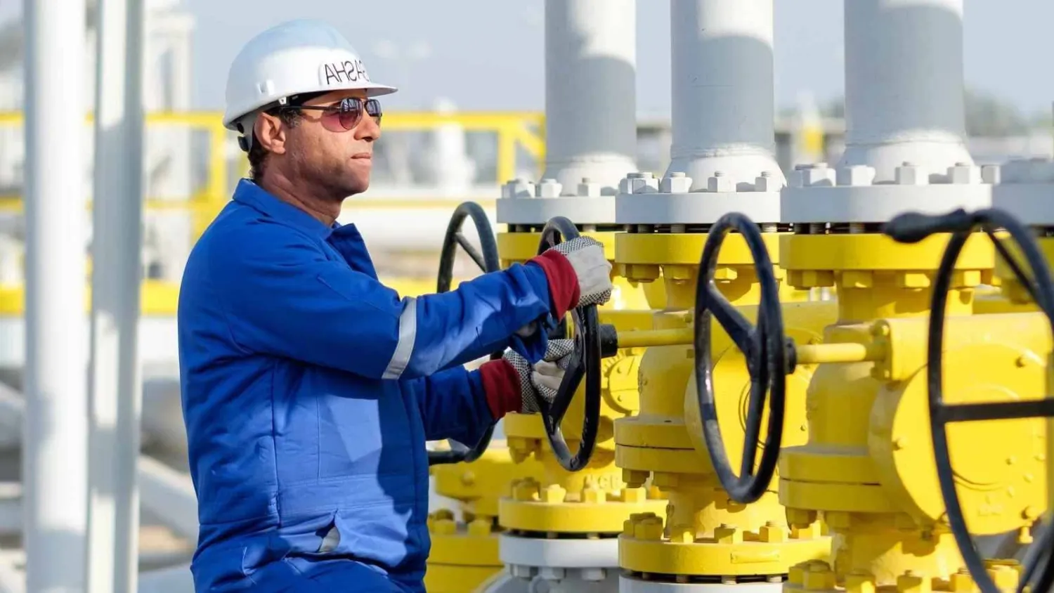 فني يدير صمام الفتح والإغلاق في منشأة للغاز تابعة لشركة «دانة غاز» الإماراتية (دانة غاز)