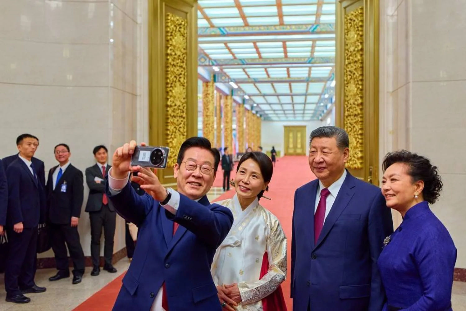South Korean President Lee Jae Myung (L) and his wife, Kim Hea Kyung (2nd from L), take a selfie with Chinese President Xi Jinping (2nd from R) and his wife, Peng Liyuan, by using a Xiaomi smartphone following a state dinner for the South Korean leader in Beijing, China, 05 January 2026. (EPA/Yonhap)