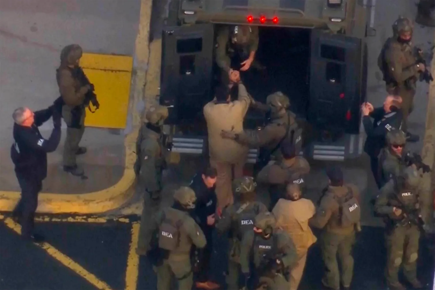 صورة من مقطع فيديو لعناصر من قوات إنفاذ القانون الفيدرالية وهم يساعدون الرئيس الفنزويلي نيكولاس مادورو وزوجته سيليا فلوريس على الصعود إلى مركبة مصفحة في طريقهما إلى المحكمة الفيدرالية بمانهاتن (أ.ب)