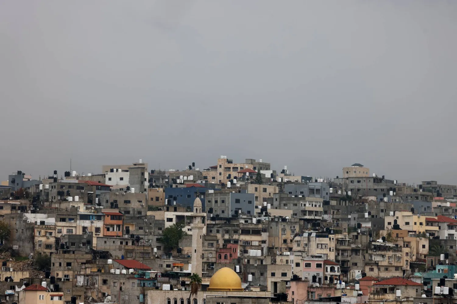 لقطة لمبانٍ خلال عملية عسكرية في مخيم نور شمس للاجئين بالقرب من مدينة طولكرم بالضفة الغربية (إ.ب.أ)