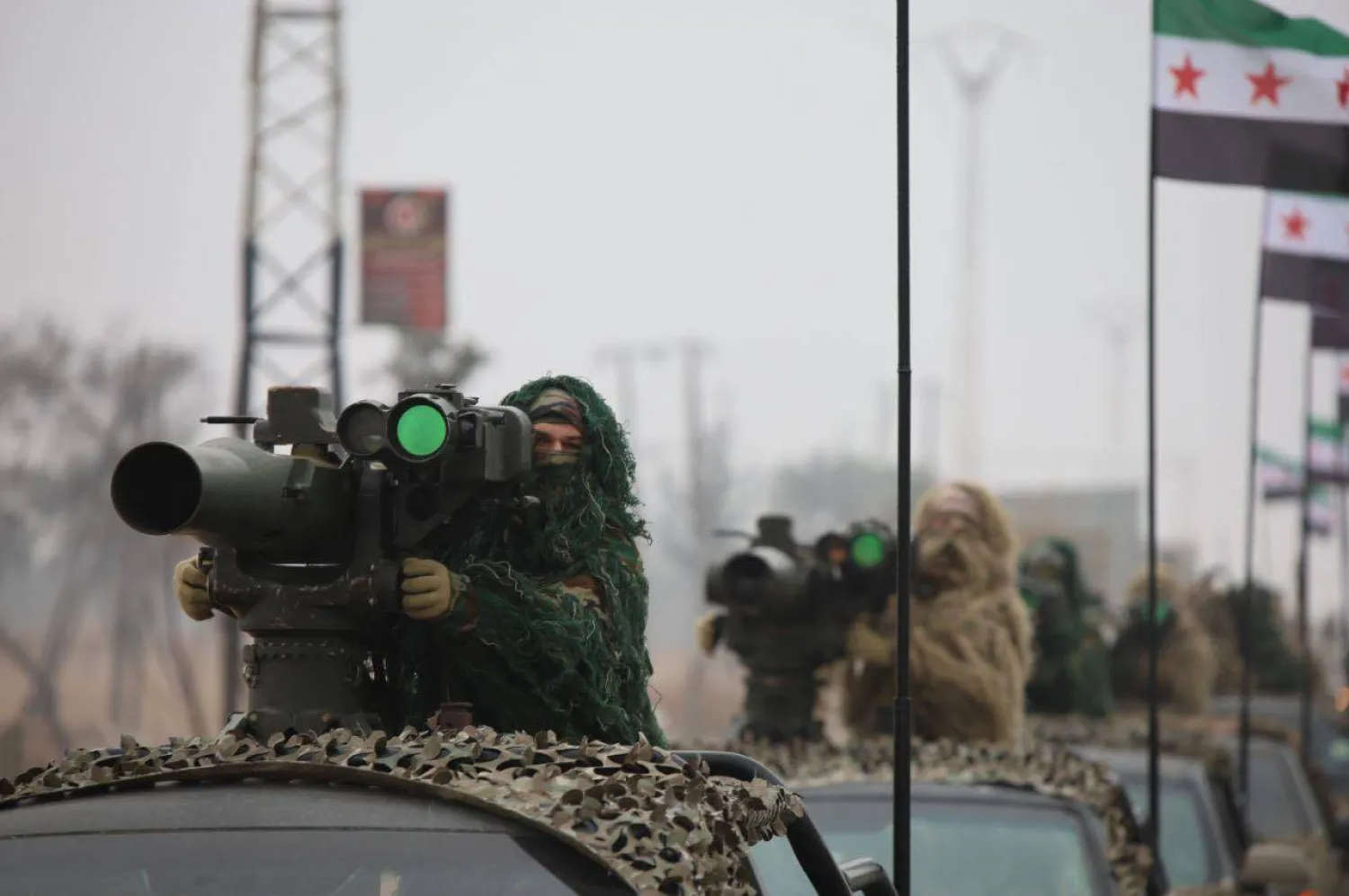 جنود من الجيش السوري وبحوزتهم قاذف مضاد للدروع خلال عرض عسكري بحلب في الذكرى الأولى للإطاحة بحكم الرئيس بشار الأسد (الدفاع السورية)