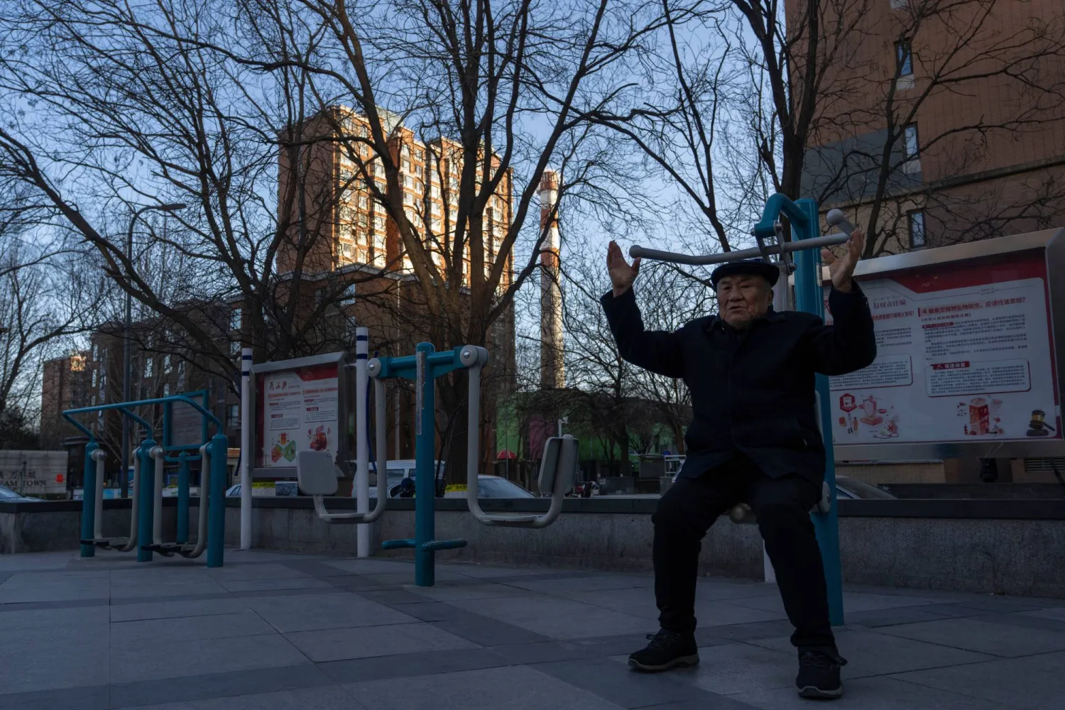 رجل مسن يمارس الرياضة بالقرب من مجمع سكني في منطقة تشانغبينغ على مشارف بكين (أ.ب)