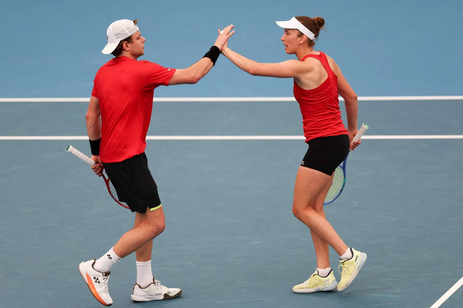 ثنائي بلجيكا زيزو بيرغيس وإليز ميرتنز يحتفلان بالفوز على كندا (أ.ف.ب)