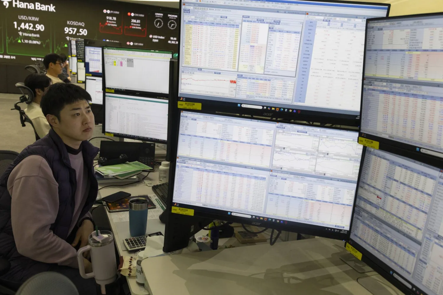 متداولون يعملون أمام شاشات تعرض مؤشرات الأسهم في بنك «هانا» بسيول (إ.ب.أ)