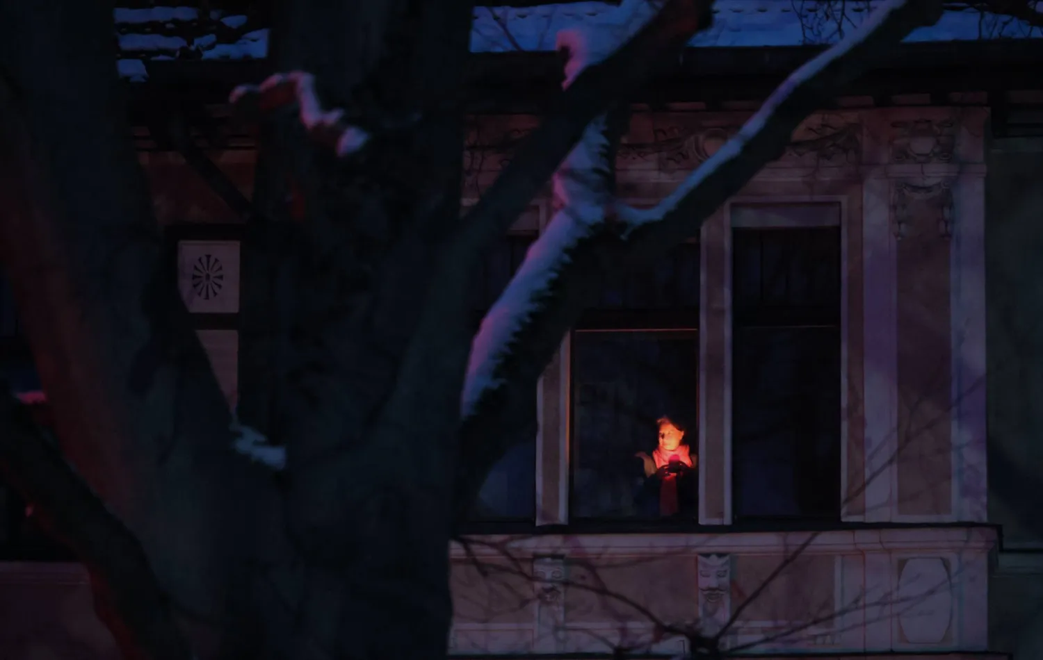 A person with a candle stands at the window during a power outage in southwest Berlin, Germany, 05 January 2026. (EPA)