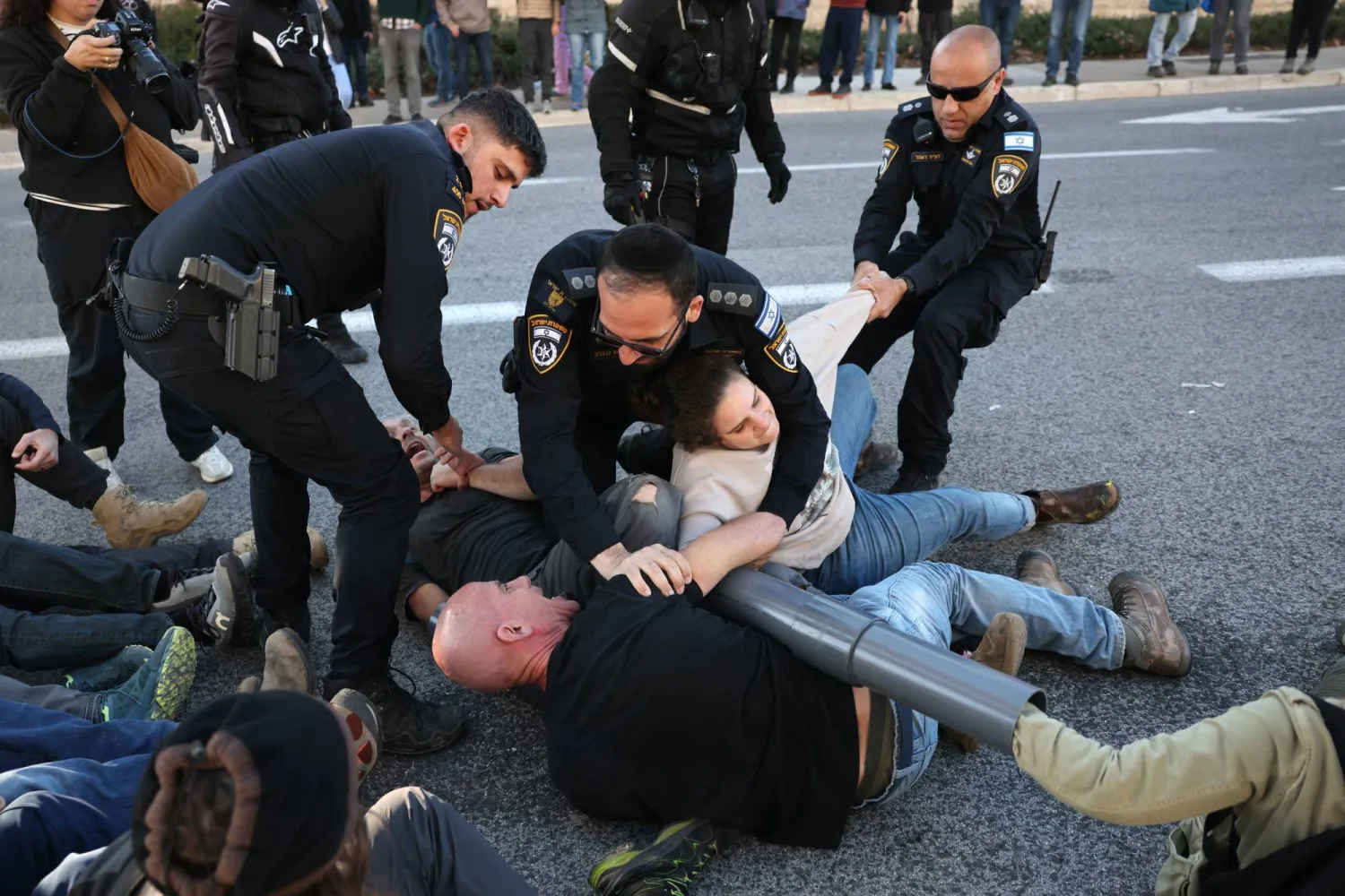 اعتقلت الشرطة الإسرائيلية متظاهرين مناهضين للحكومة قاموا بتقييد أنفسهم بالسلاسل في محاولة لإغلاق الطريق الرئيسي أمام المحكمة العليا الإسرائيلية في القدس (إ.ب.أ)