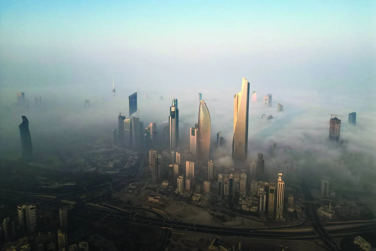 ناطحات السحاب وسط ضباب الصباح في مدينة الكويت (أ.ف.ب)