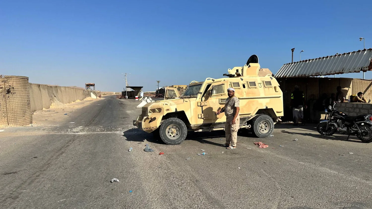  جندي حكومي يقف بجوار مركبة عسكرية خارج قاعدة عسكرية في مدينة المكلا كبرى مدن حضرموت (رويترز)