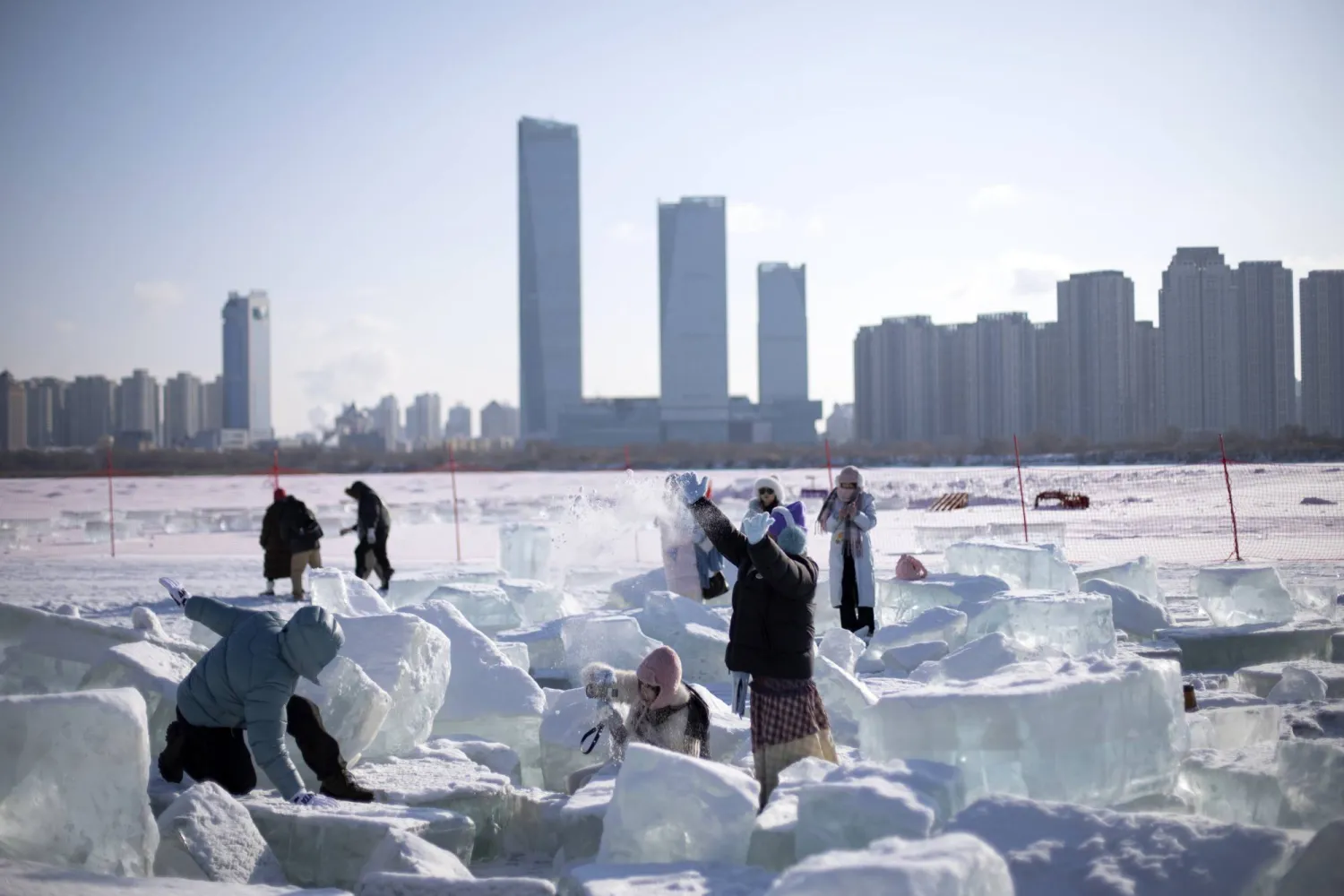 مواطنون يستمتعون بالثلوج في مدينة هاربين وسط الصين (إ.ب.أ)