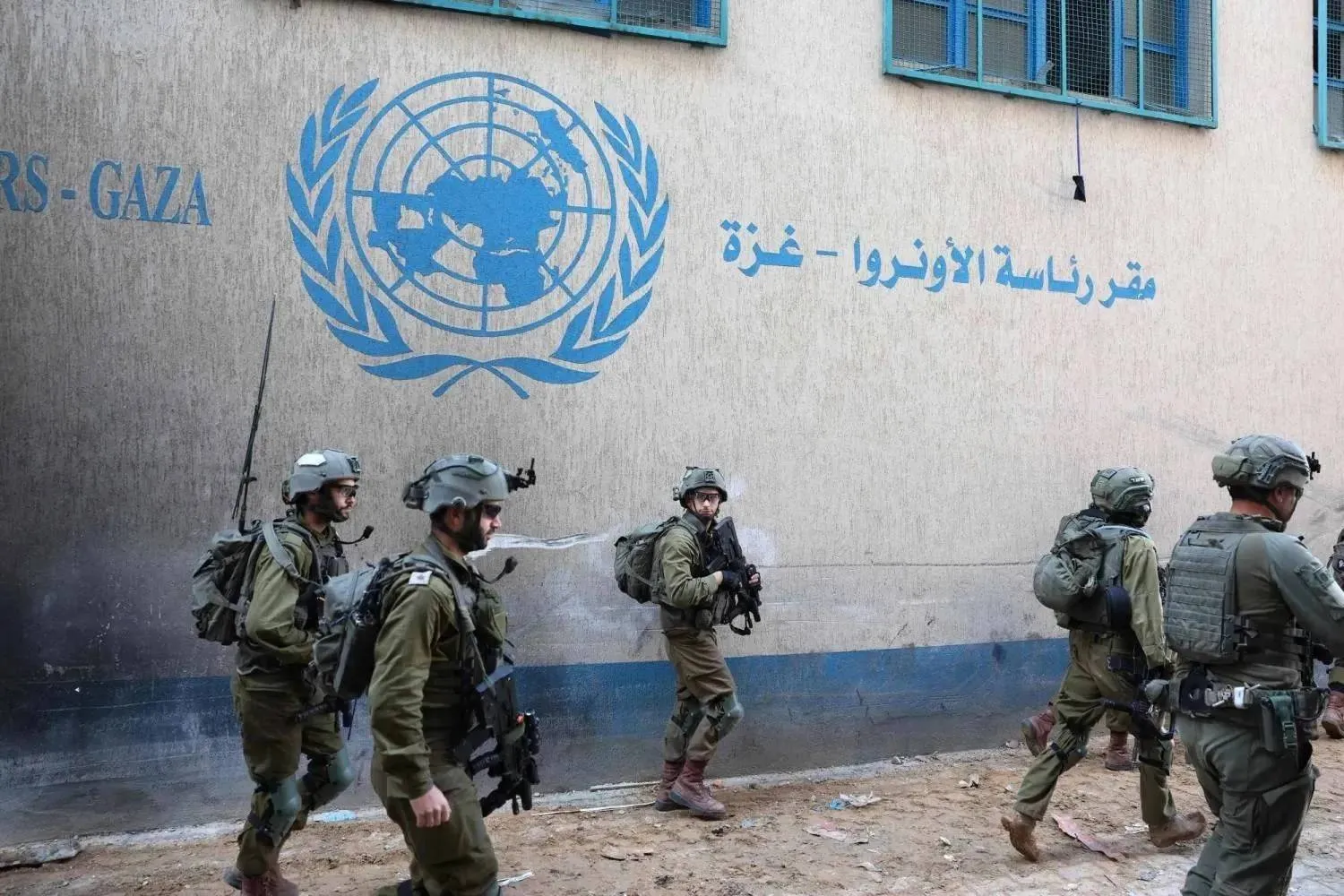 Israeli soldiers stand outside UNRWA’s headquarters in the Gaza Strip (AFP)