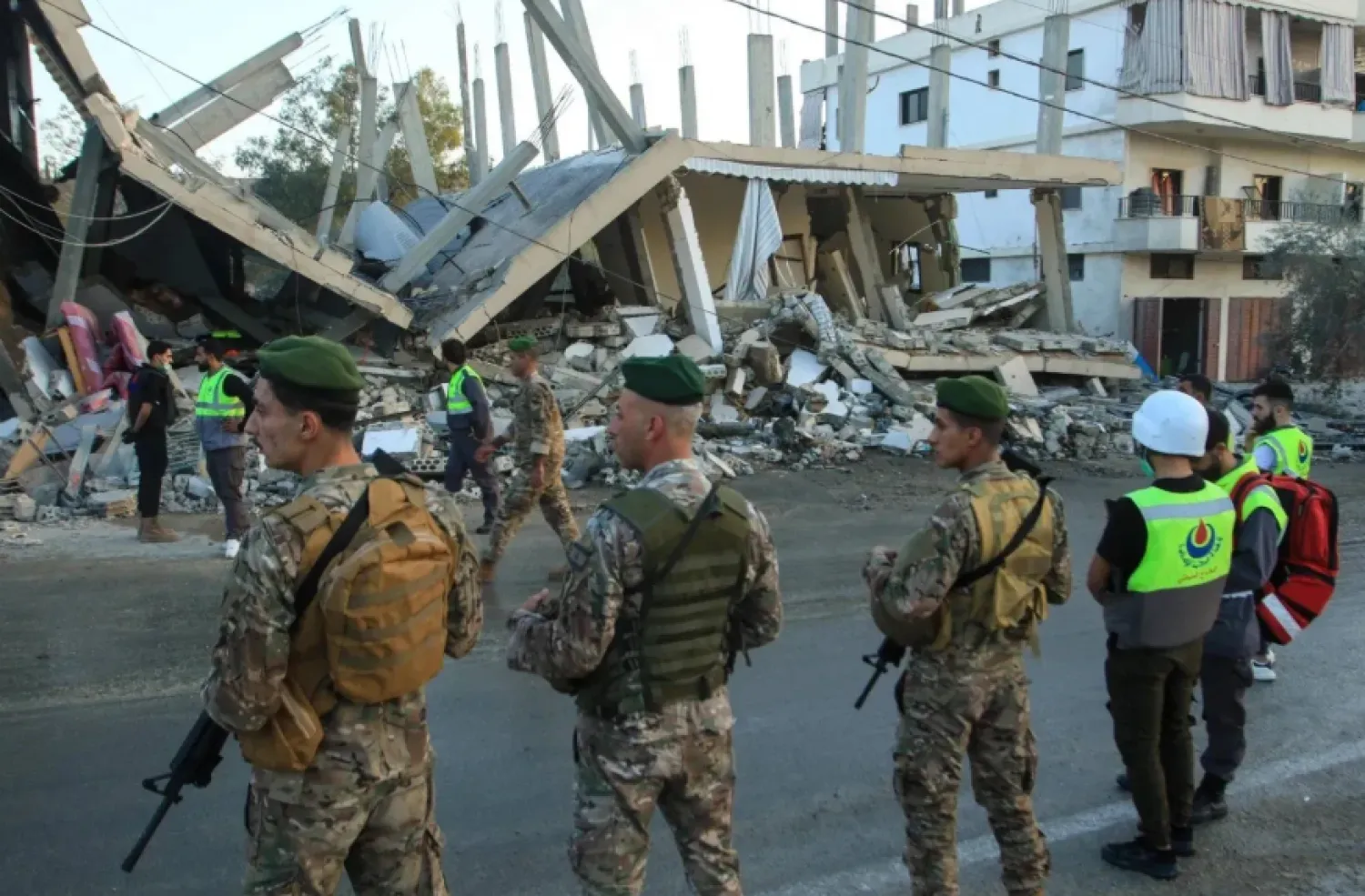 Lebanese soldiers stand in front of a building targeted by an Israeli airstrike in the village of Deir Kifa in south Lebanon last month. (AFP file)
