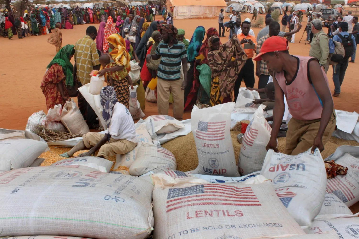 FILE - Workers distribute food aid from the World Food Program at a refugee camp in Dolo, Somalia on July 18. 2012. (AP Photo/Jason Straziuso, file)