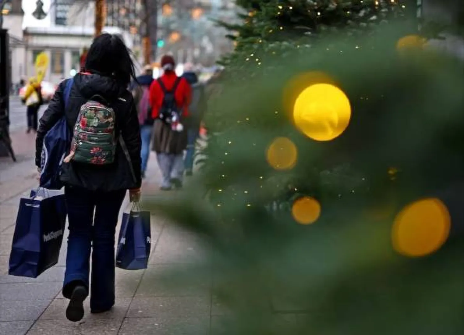 متسوقون خارج متجر «كاوفهاوس ديس ويستنس» خلال موسم عيد الميلاد في برلين (رويترز)