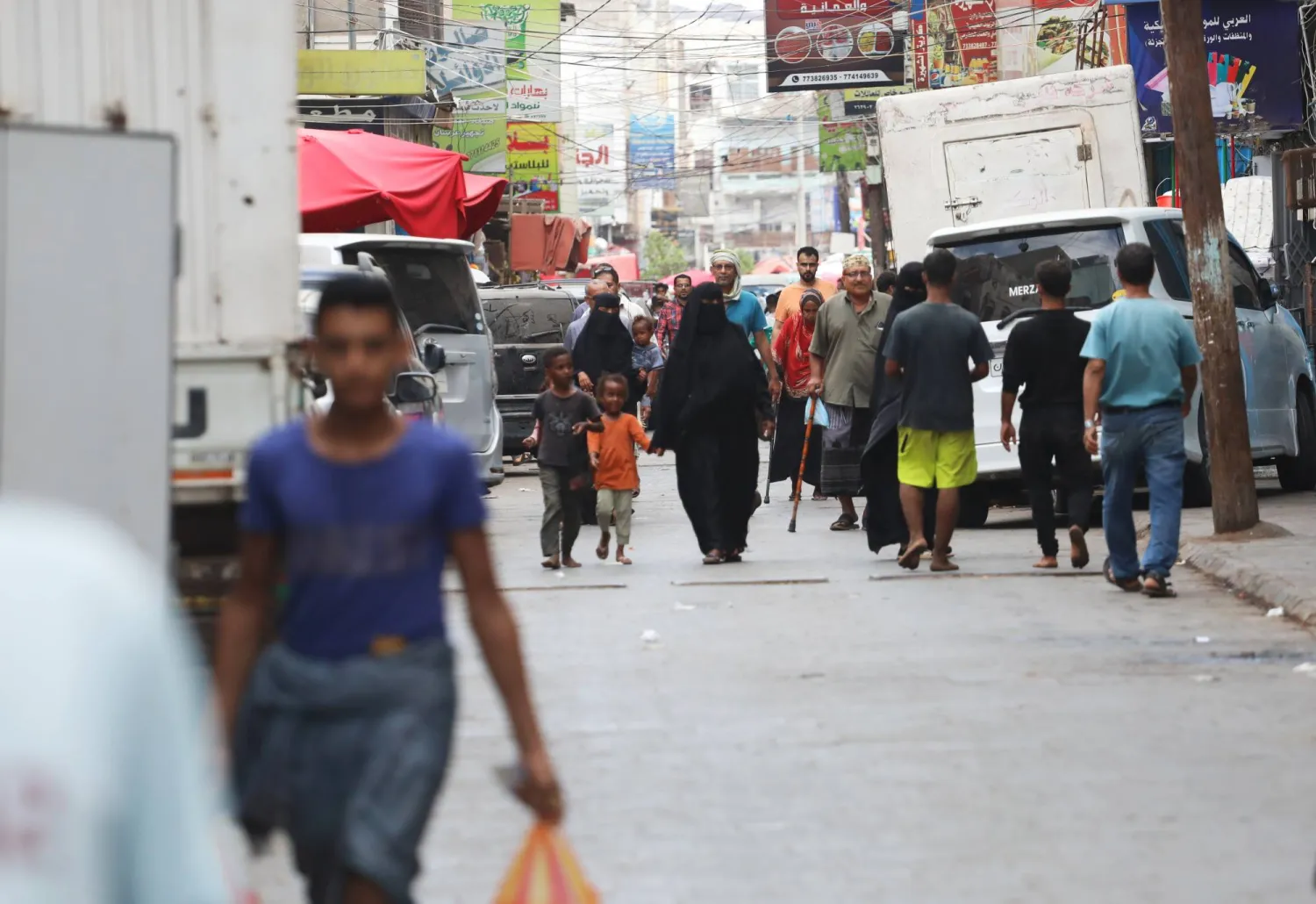 يمنيون يسيرون في سوق بمدينة عدن (إ.ب.أ)