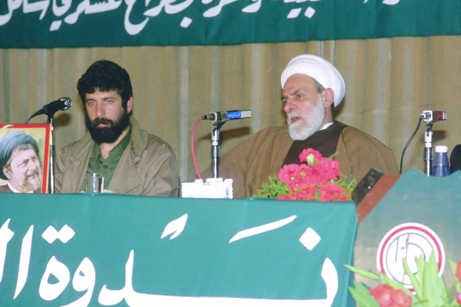 الشيخ محمد مهدي شمس الدين خلال إحدى المناسبات مع القيادي العسكري في حركة أمل عقل حمية (غيتي)