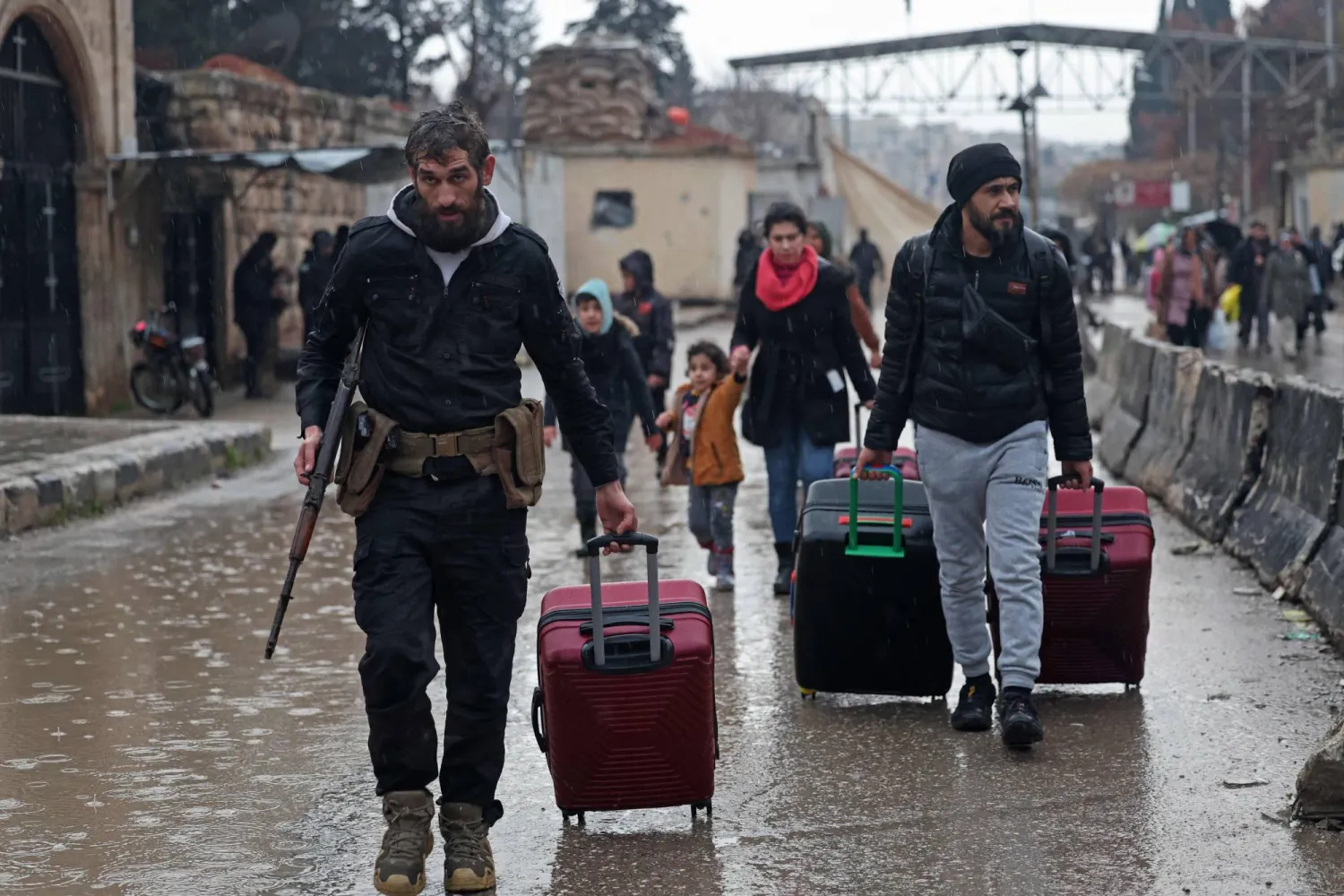 TOPSHOT - Residents of Aleppo's Sheikh Maqsud area evacuate their neighborhood after warnings from the Syrian army that called on civilians to get out of harms way, following the refusal of Kurdish fighter forces to leave Aleppo, on January 9, 2026. (Photo by OMAR HAJ KADOUR / AFP)